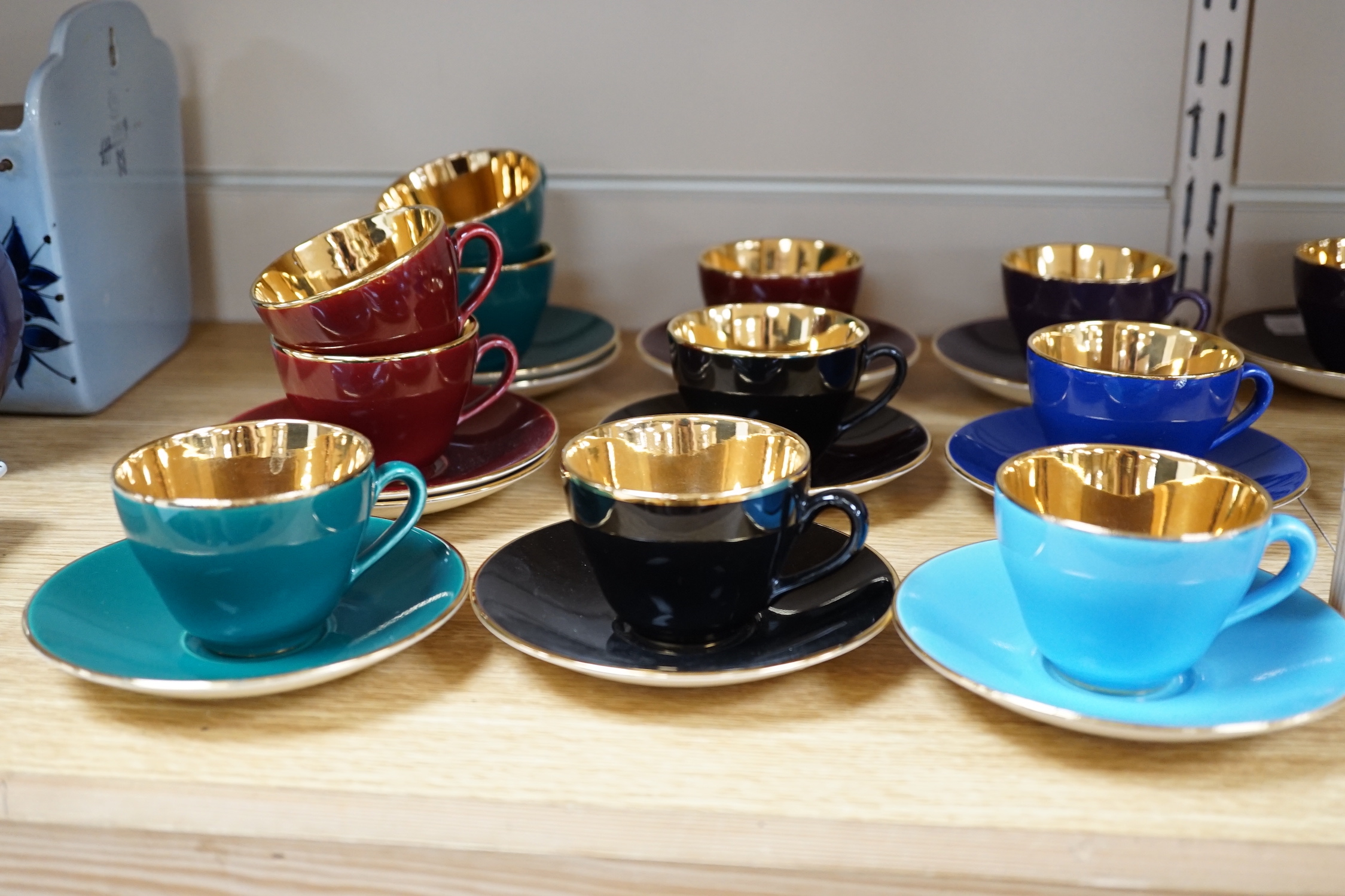 Fourteen Copenhagen Alumina, ‘Confetti’ patterned coffee cups and saucers in varying colours with gilt interiors